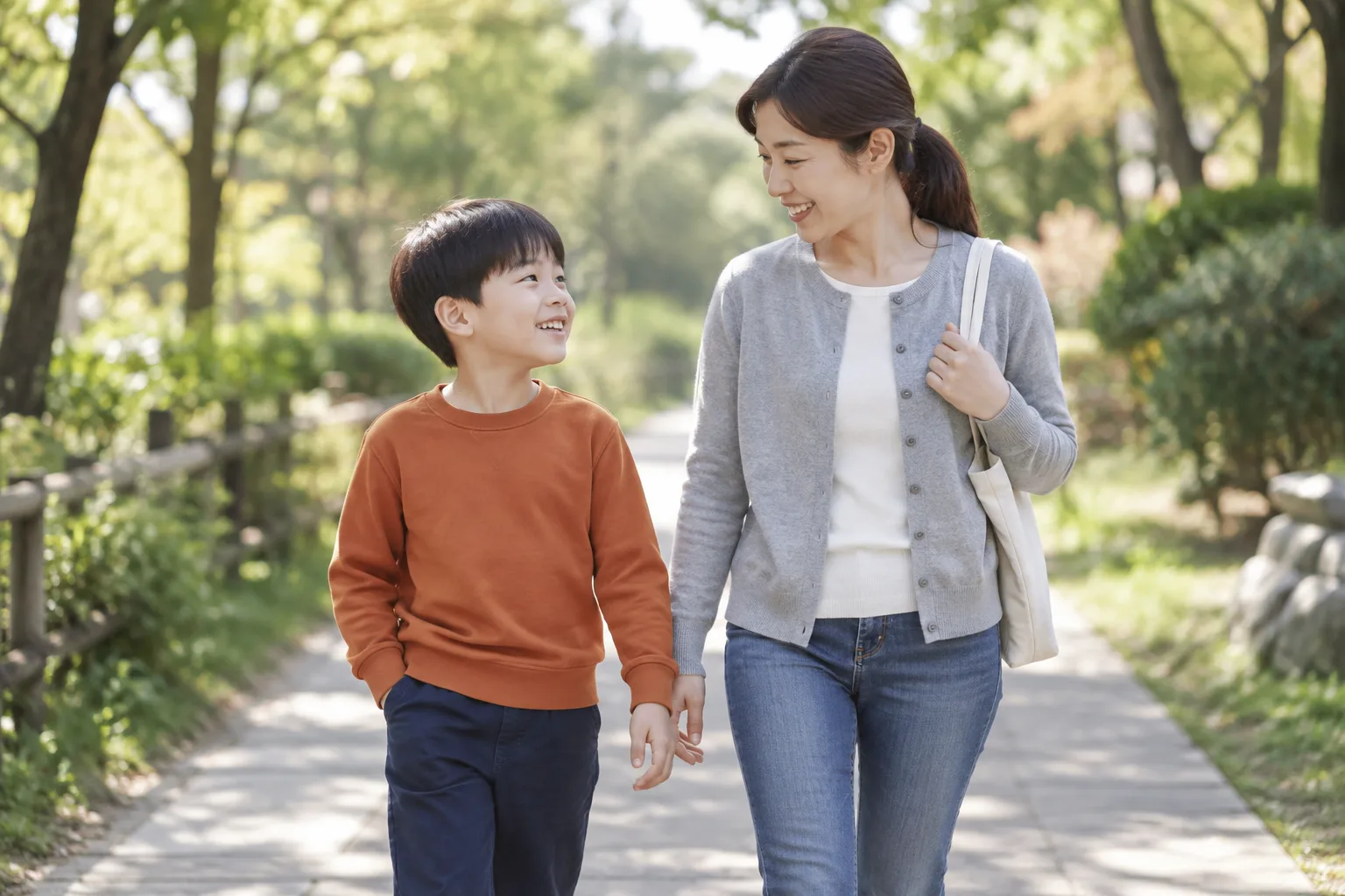 낮에 어머니와 공원 길을 걸으며 대화하는 아동